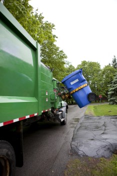 Worker wearing PPE handling segregated waste bins