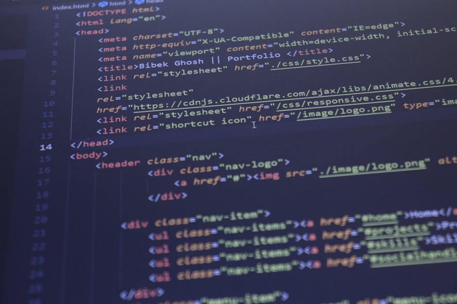 A close-up view of a laptop computer on a desk, displaying lines of programming code in a text editor on the left side of the screen. The code includes HTML and CSS elements with color-coded syntax. T